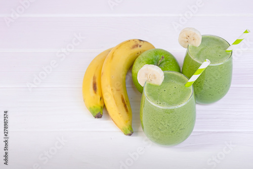 Banana mix apple smoothie green juice beverage healthy the taste yummy in glass for on white wood background.