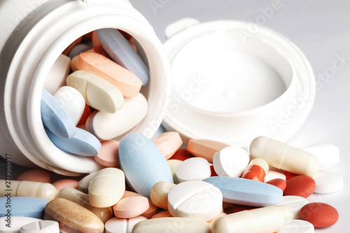 and a variety of multi-colored pills spilled from the pill box