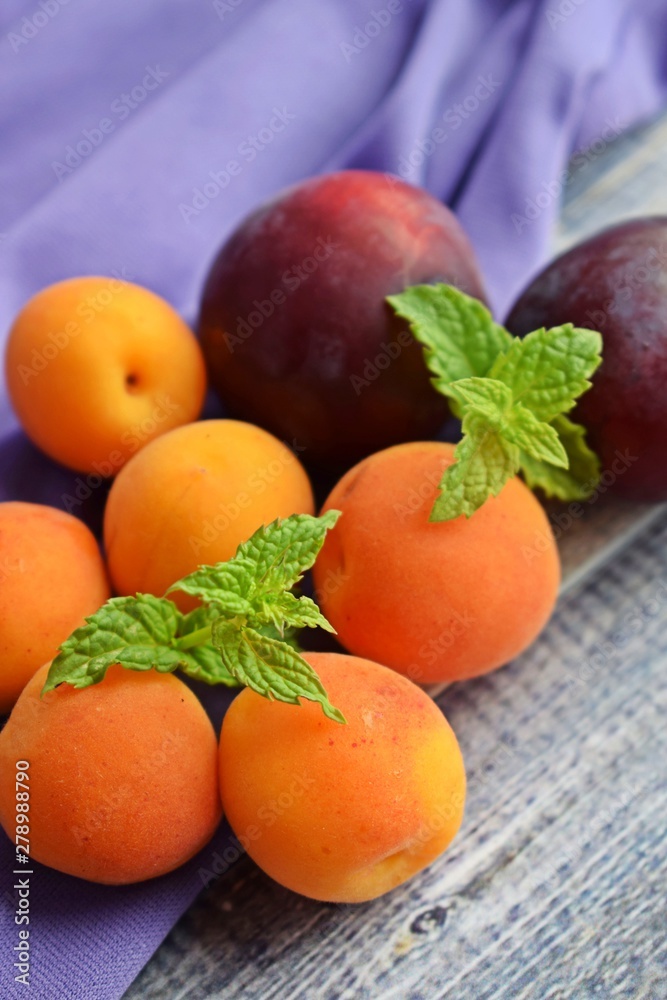 Ripe,sweet apricots and plums on wooden background.