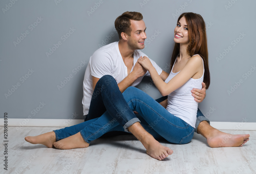 Beautiful young amorous couple, sitting on floor Beautiful young amorous couple, sitting on floor