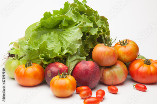 Lechuga verde y distintas frutas  tomates  cherri y de los otros  nectarinas todo sobre fondo blanco