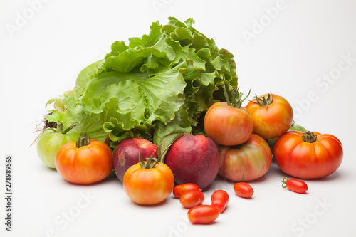 Lechuga verde y distintas frutas  tomates  cherri y de los otros  nectarinas todo sobre fondo blanco