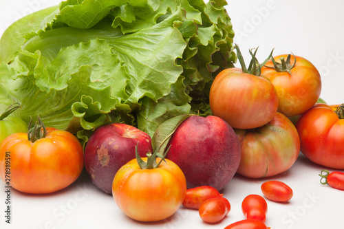 Lechuga verde y distintas frutas, tomates, cherri y de los otros, nectarinas todo sobre fondo blanco