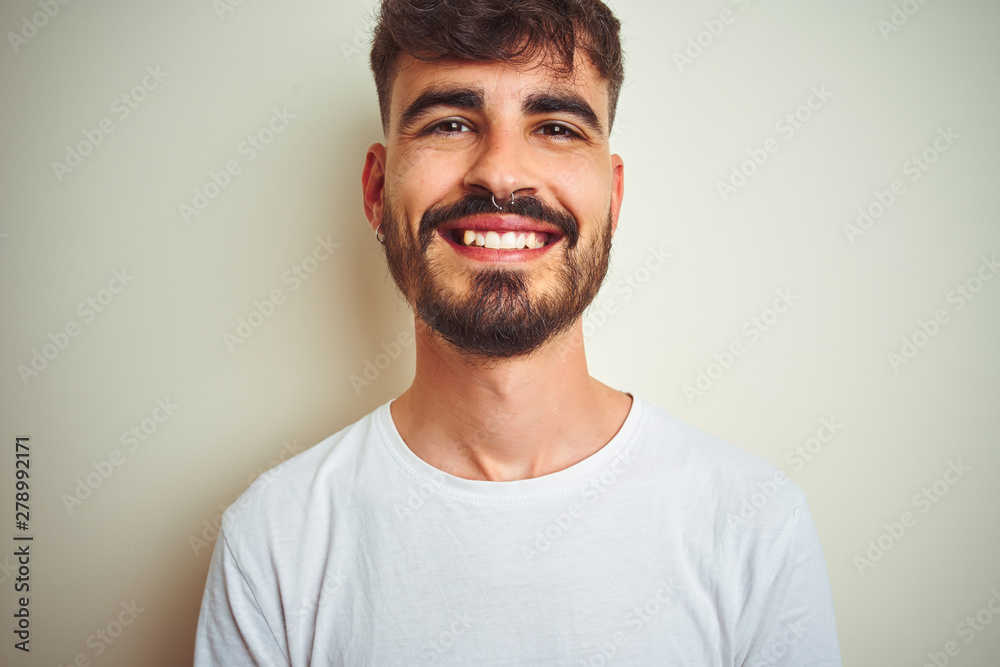 Young man with tattoo wearing t-shirt standing over isolated white background with a happy and cool smile on face. Lucky person. Young man with tattoo wearing t-shirt standing over isolated white background with a happy and cool smile on face. Lucky person.