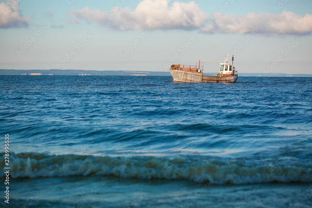 old fishing boat going on the sea waves