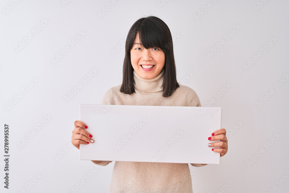 Young beautiful Chinese woman holding banner standing over isolated white background with a happy face standing and smiling with a confident smile showing teeth Young beautiful Chinese woman holding banner standing over isolated white background with a happy face standing and smiling with a confident smile showing teeth