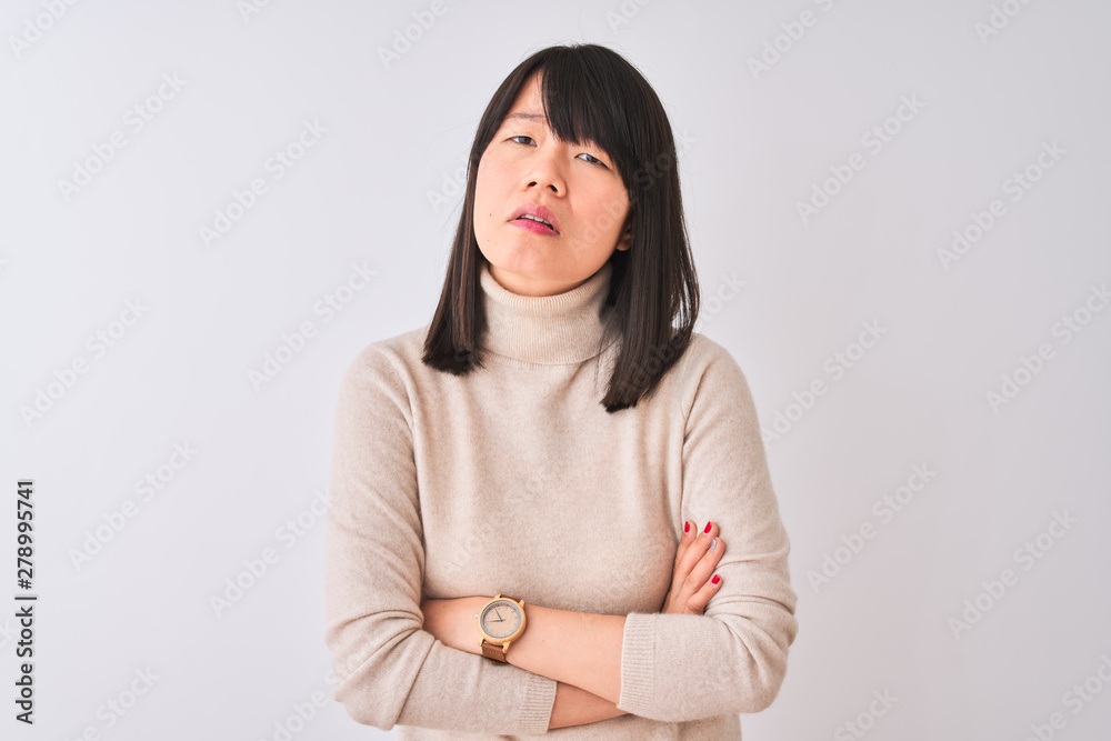Young beautiful chinese woman wearing turtleneck sweater over isolated white background skeptic and nervous, disapproving expression on face with crossed arms. Negative person. Young beautiful chinese woman wearing turtleneck sweater over isolated white background skeptic and nervous, disapproving expression on face with crossed arms. Negative person.