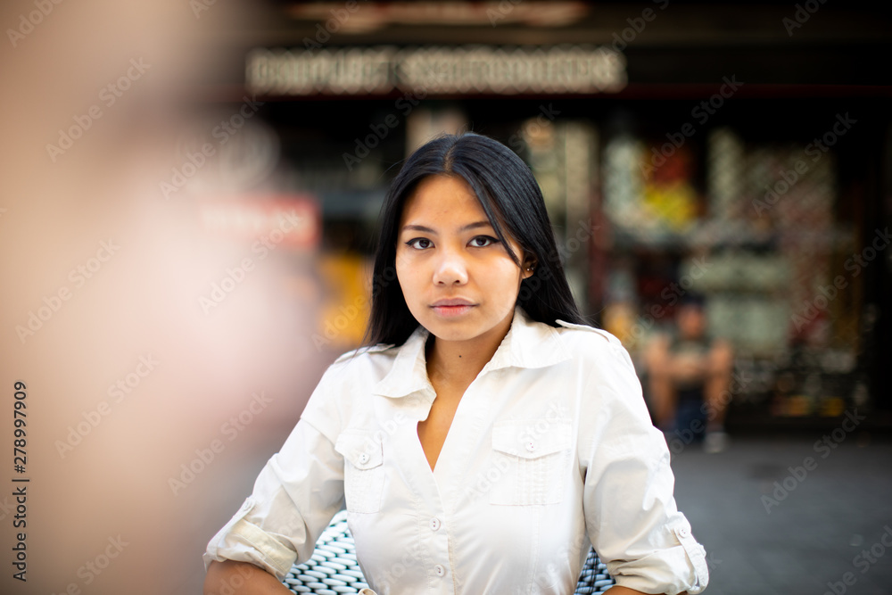 Asiatic woman in the street touching her hair
