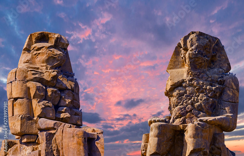 Colossi of Memnon Luxor Thebes against the background of dawn in the mountains