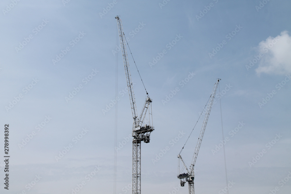 Two High Vertical Building Construction Tower Cranes. Two High Vertical Building Construction Tower Cranes.