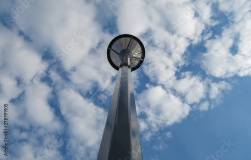 Metal streetlight under blue sky and white clouds