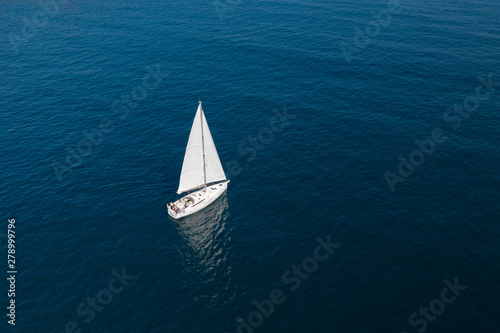 Foto white sailing yacht in the blue sea top view