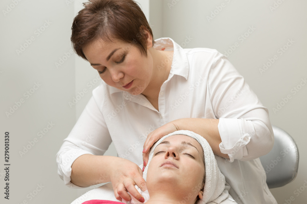 Face skin care. Beautician applying beauty oil mask on face using brush In spa salon