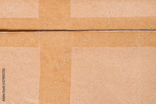 Cardboard box crossed by adhesive tape texture