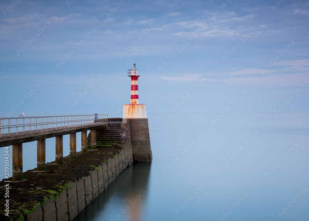 View of Amble Pier at the entrance to Amble Harbour, Amble, Northumberland, England, UK. In evening light.