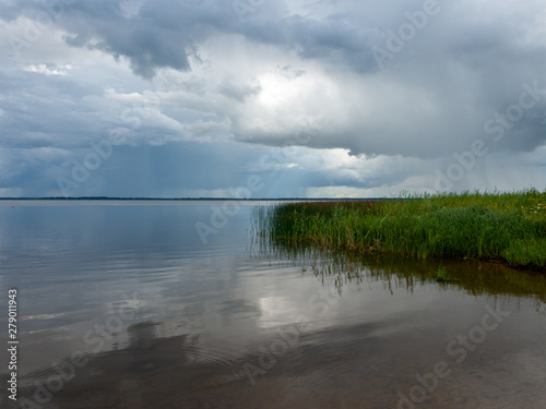 Beautiful  peaceful lake shore with storm clouds  wonderful reflections  Lake Burtnieks  Latvia