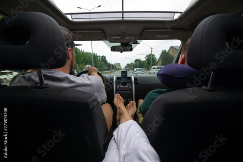 woman sitting at backseats of car put legs on armrest sunroof © phpetrunina14