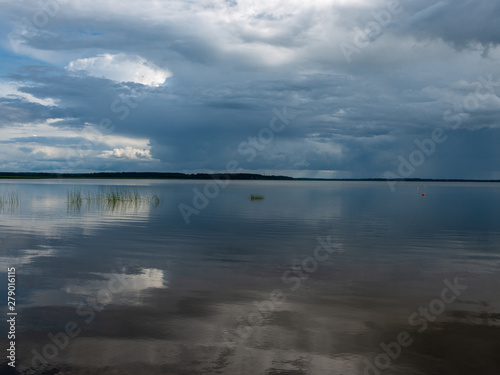 Storm clouds rolling in over peaceful lake,wonderful reflections, Lake Burtnieks, Latvia