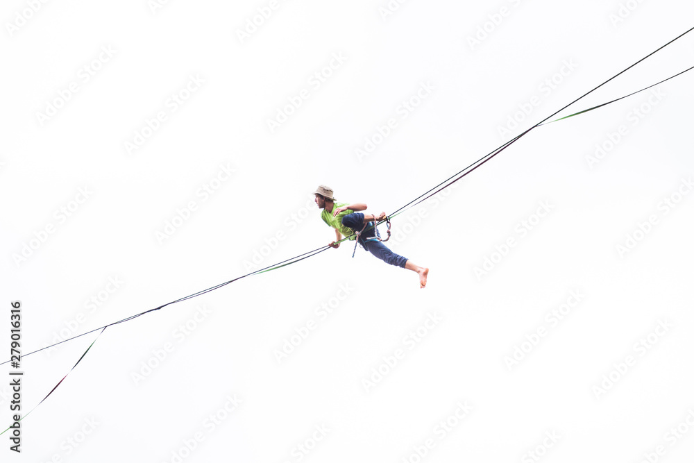 A man sits on a stretched sling on a white background. A man sits on a stretched sling on a white background.