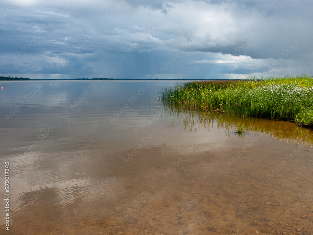 Beautiful, peaceful lake shore with storm clouds, wonderful reflections, Lake Burtnieks, Latvia Beautiful, peaceful lake shore with storm clouds, wonderful reflections, Lake Burtnieks, Latvia