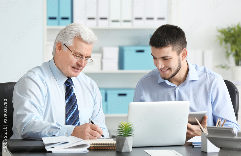 Mature marketing manager with trainee in office Mature marketing manager with trainee in office