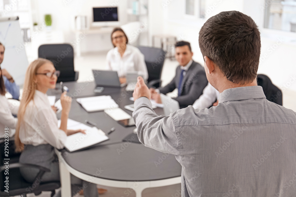 Business trainer giving presentation to group of people at management seminar Business trainer giving presentation to group of people at management seminar