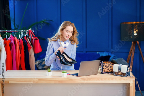 Young female fashion blogger presenting pair of shoes to the camera. photo