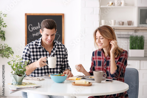 Happy couple having breakfa...