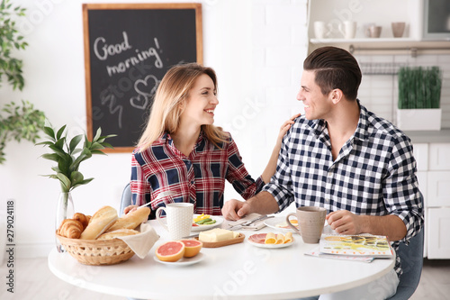 Happy couple having breakfa...