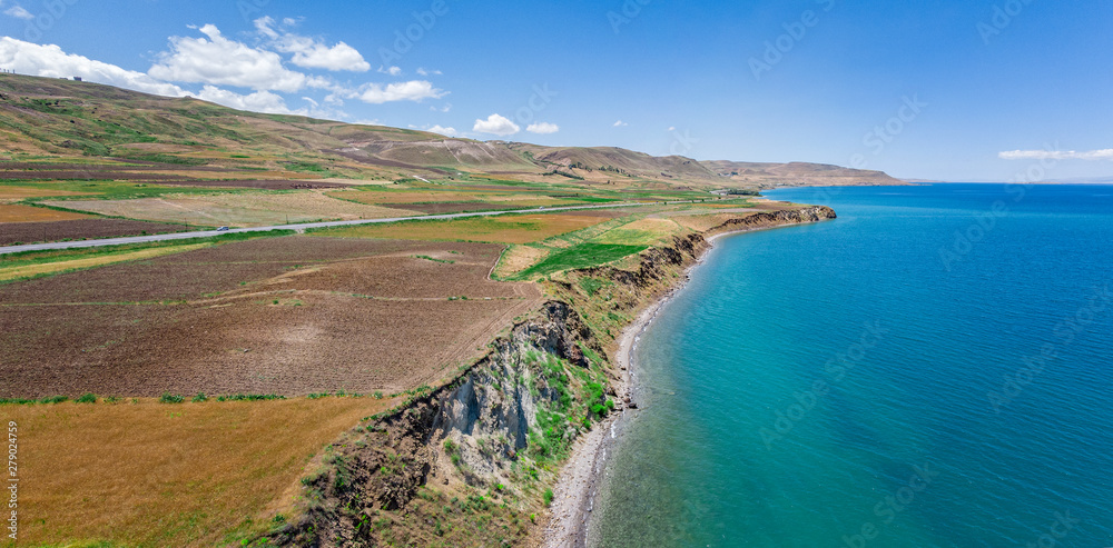 Aerial view of Lake Van the largest lake in Turkey, lies in the far east of that country in the provinces of Van and Bitlis. Fields and cliffs overlooking the crystal clear waters. Roads