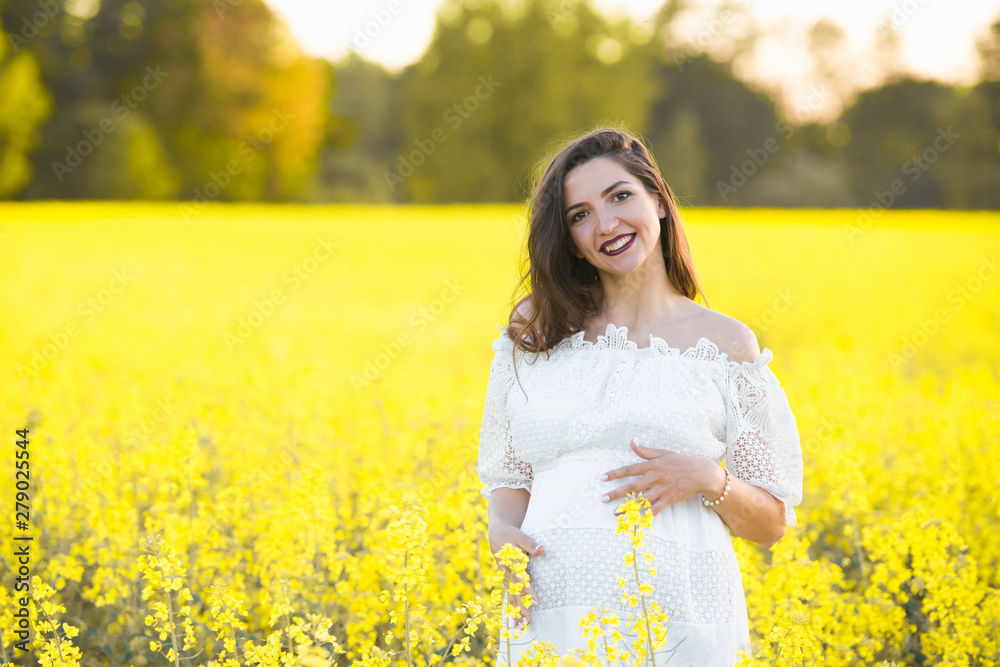 Pregnant girl on the rapeseed field. cute young woman waiting a baby Pregnant girl on the rapeseed field. cute young woman waiting a baby