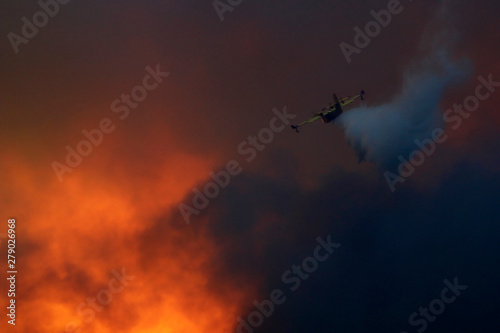 Canadair gasing the fire through the smoke in the sky