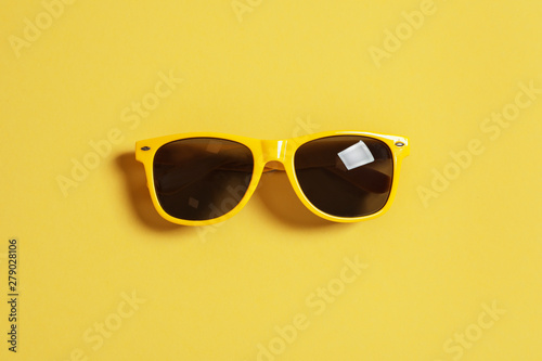 Stylish sunglasses on color background, top view. Beach accessories
