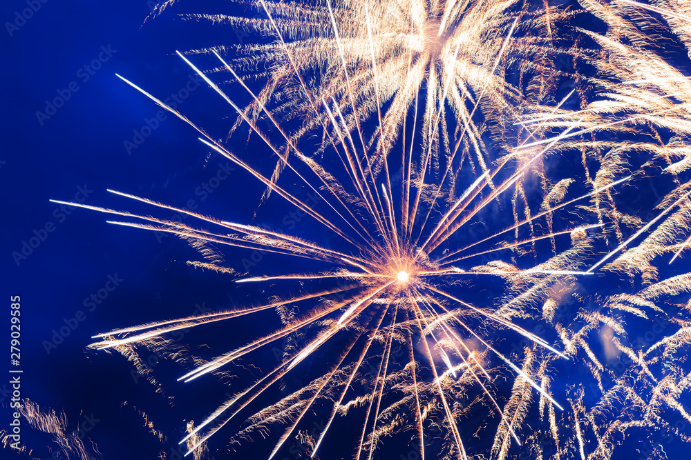Fototapeta premium Fireworks over the city yellow, blue and white. Bright and shiny. For any purpose. Celebration concept.