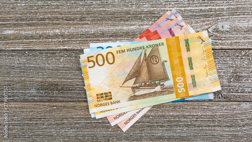Norwegian kroner bills stacked on wood table