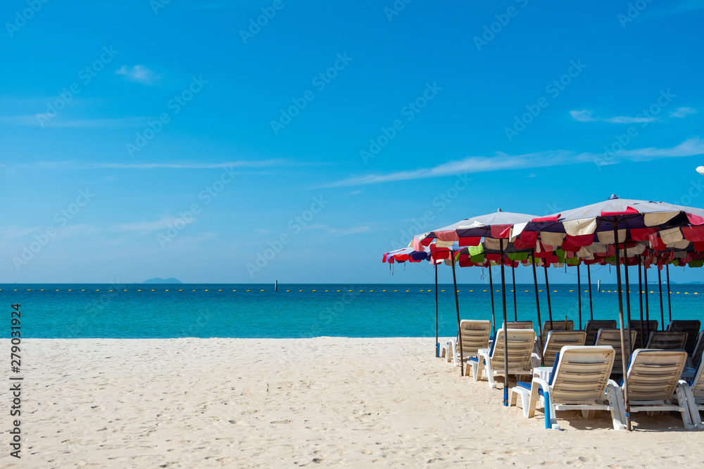 Beach chairs on sand beach with blue sky