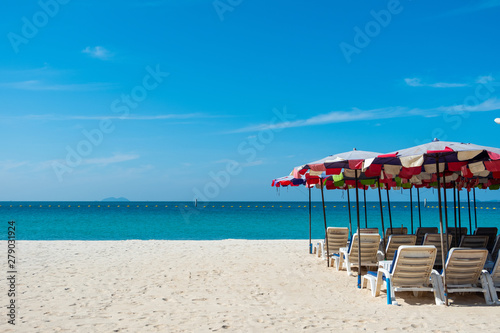 Beach chairs on sand beach with blue sky