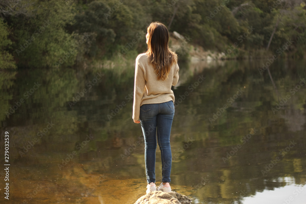 Woman standing on a rock near the lake