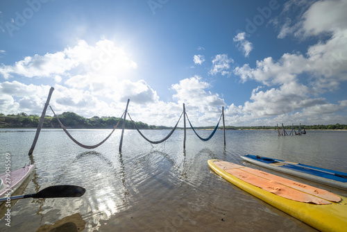Tranquil water, two stand up paddle board at the shore and bright sun. Natal, Rio Grande do Norte, Brazil.
