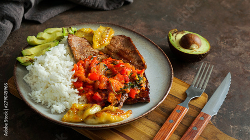 Fototapeta Naklejka Na Ścianę i Meble -  colombian food. El Bistec a la Criolla  -  traditional beef steak with tomatoes sauce, rice, avocado, bananas fries 