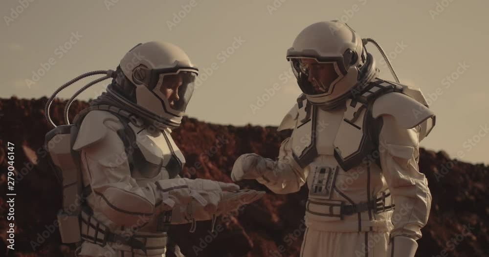 Two astronauts examining sample on Mars
