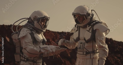Two astronauts examining sample on Mars
