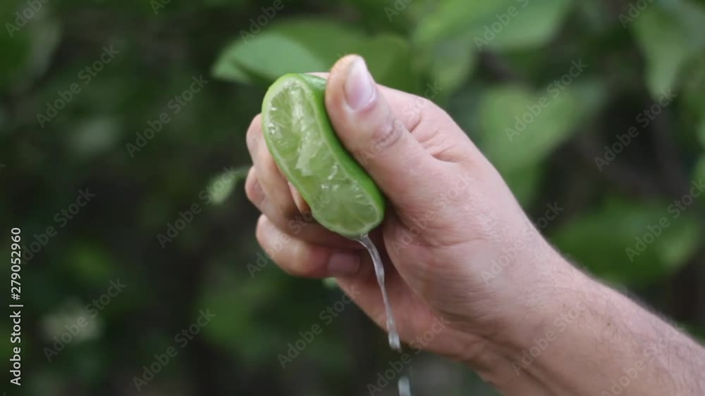 Mano exprimiendo limón