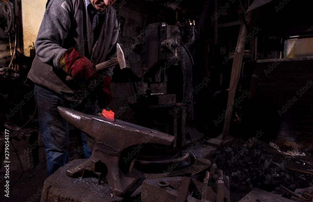 blacksmith manually forging the molten metal