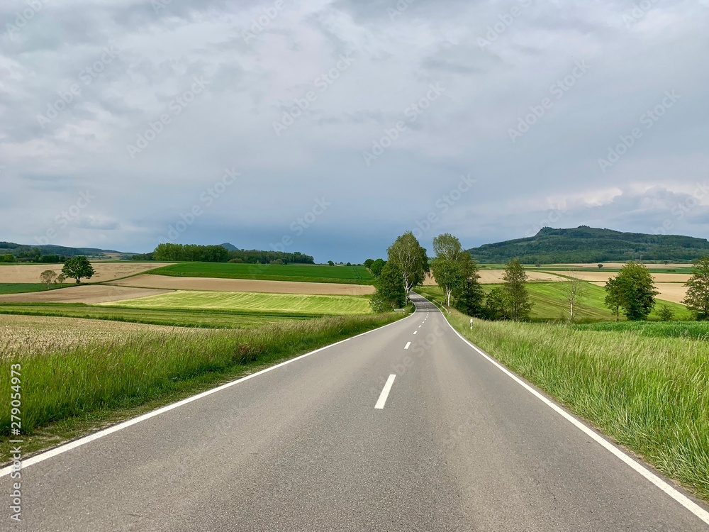 Leere Landstrasse - Autostrasse durch Landwirtschaftszone - Felder und Wiesen Leere Landstrasse - Autostrasse durch Landwirtschaftszone - Felder und Wiesen