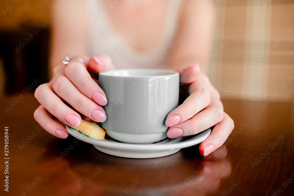 Female hands hold hot grey coffee cup beverage, drinks cappuccino. Horizontal several objects copyspace Female hands hold hot grey coffee cup beverage, drinks cappuccino. Horizontal several objects copyspace
