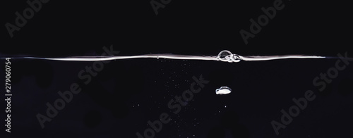 Several big and many small water bubbles isolated on black background, close up view. Bubbles underwater and rippling liquid surface. Background for overlays design, screen blending mode layer
