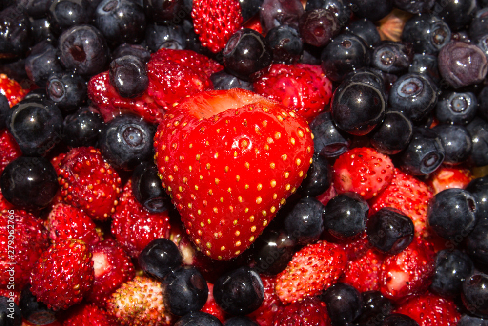 Blueberries and strawberries top view.Background of berries.A mixture of blueberries and strawberries.