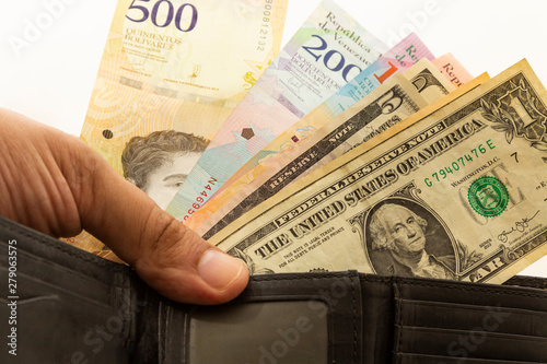 Black leather wallet with Venezuelan money bolivars and US dollar currency.