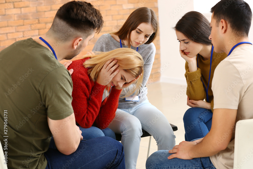 People calming woman at group therapy session People calming woman at group therapy session